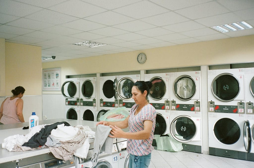 photo of woman standing inside the laundromat